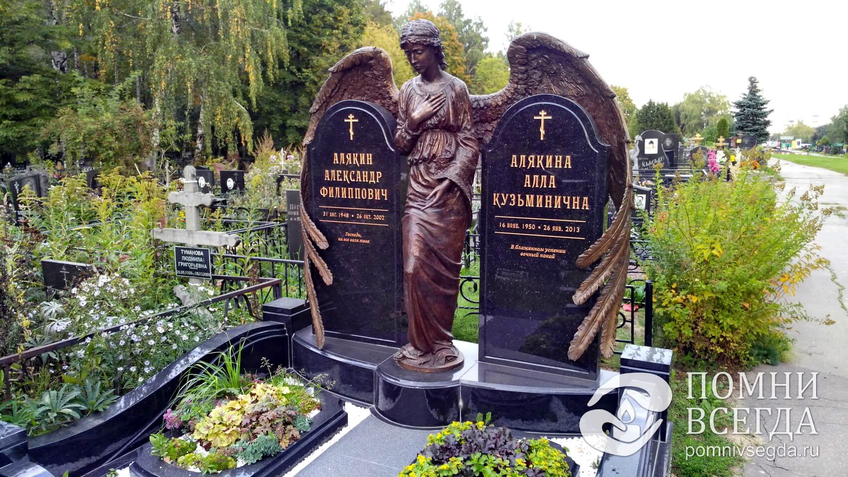 Охватывающая оба надгробья широкими крыльями скульптура ангела
